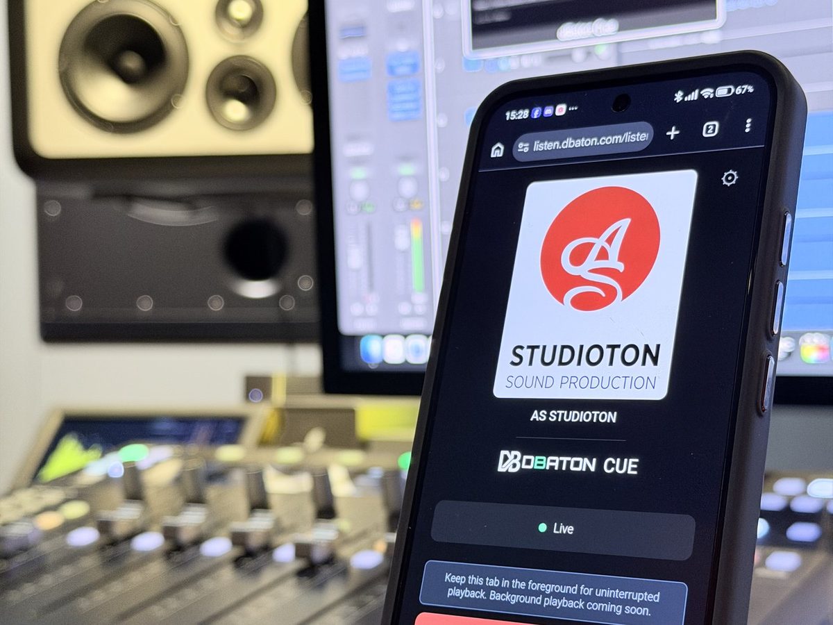 A phone showing the CUE listening page with AS Studioton's logo, in front of a mixing console