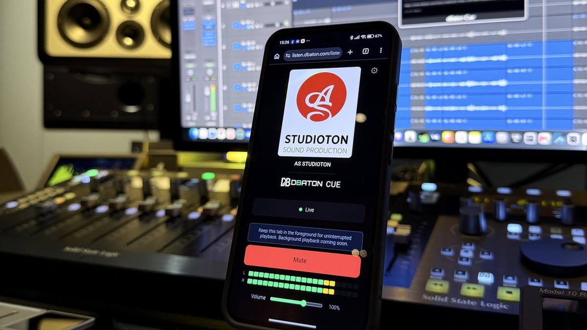 A studio session in Logic with the CUE listening page open on a phone, showing the AS Studioton logo above the dBaton CUE mark